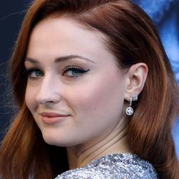 close up shot of sophie turner on the red carpet with red wavy hair