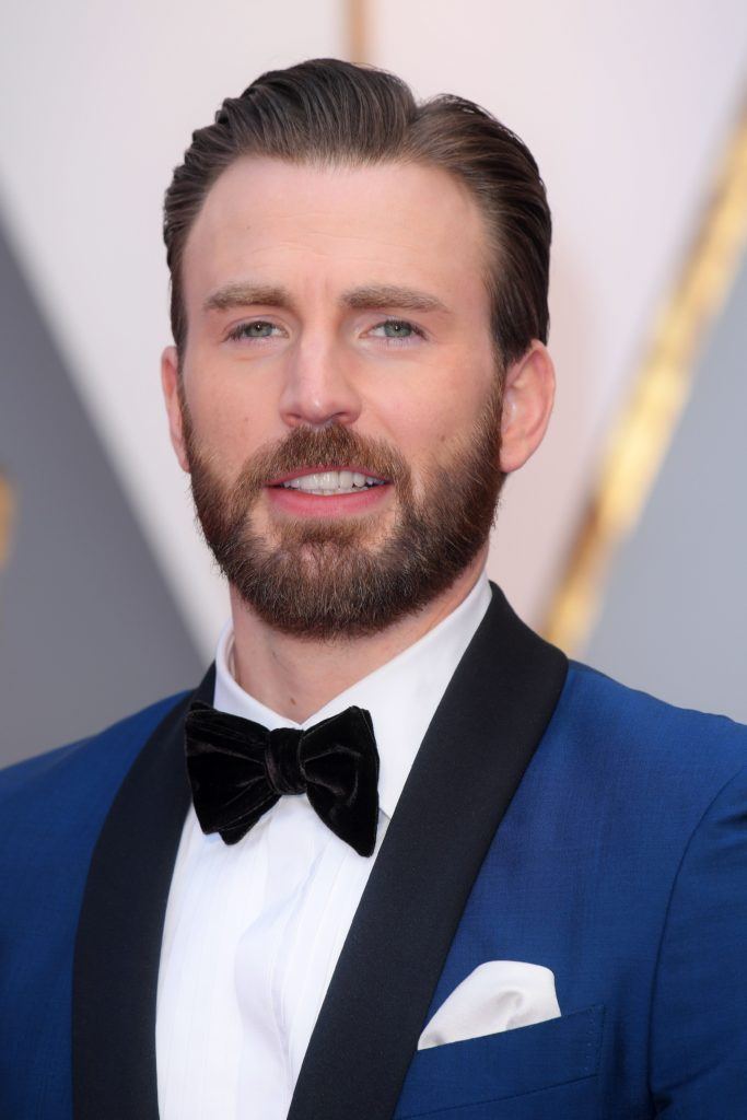 chris evans with slick side part and blue suit with bow tie