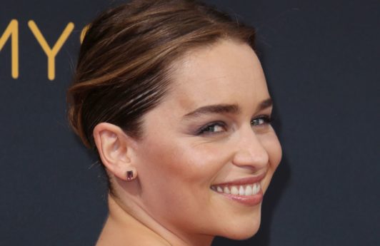 Game of Thrones actress Emilia Clarke on the red carpet with her brunette hair in a sleek low bun