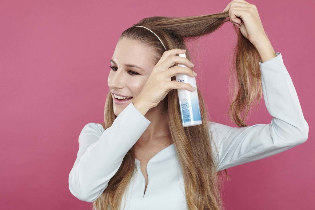 girl backcombing her long brown hair