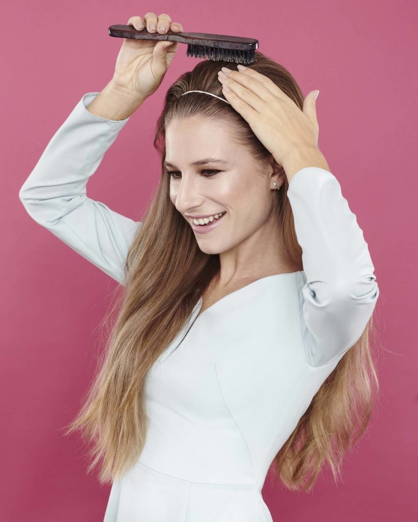 girl backcombing her long brown hair