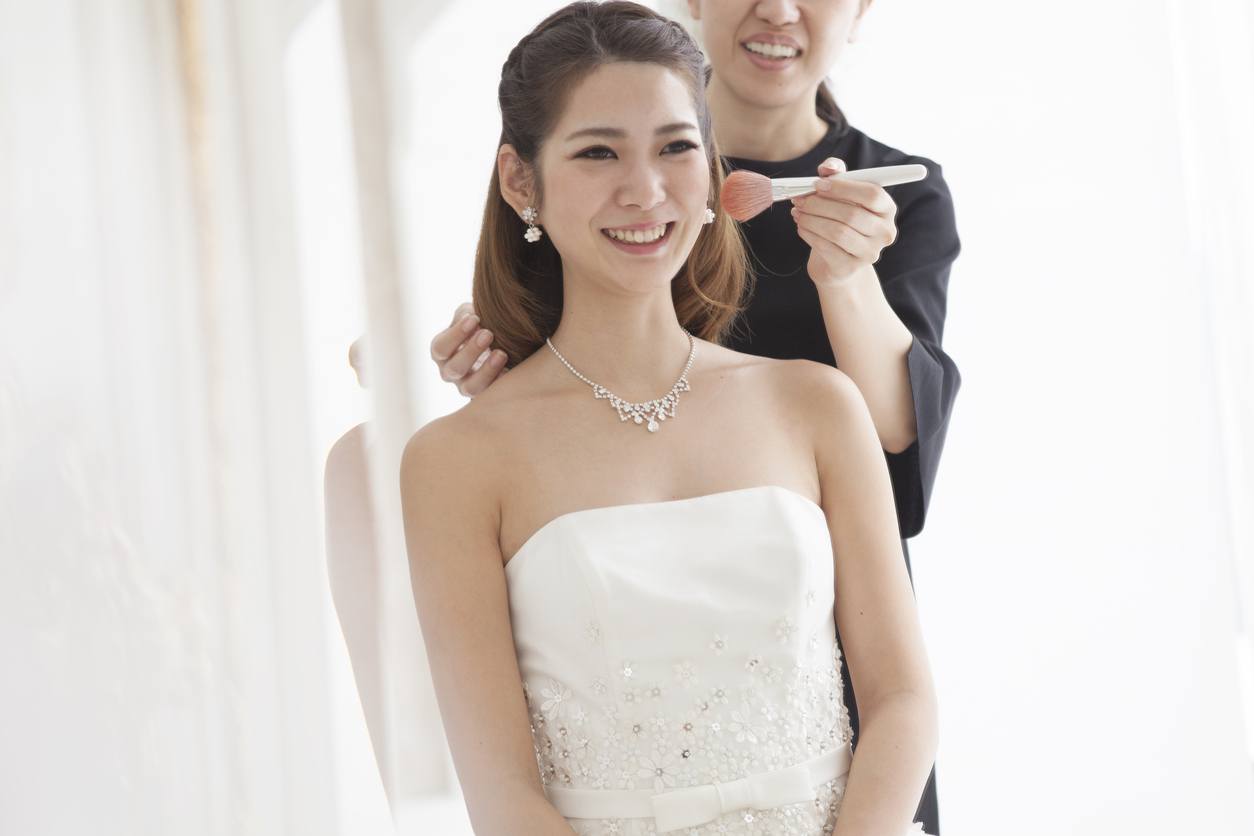 asian bride wearing strapless white gown with her long brunette hair styled into a half up half down look