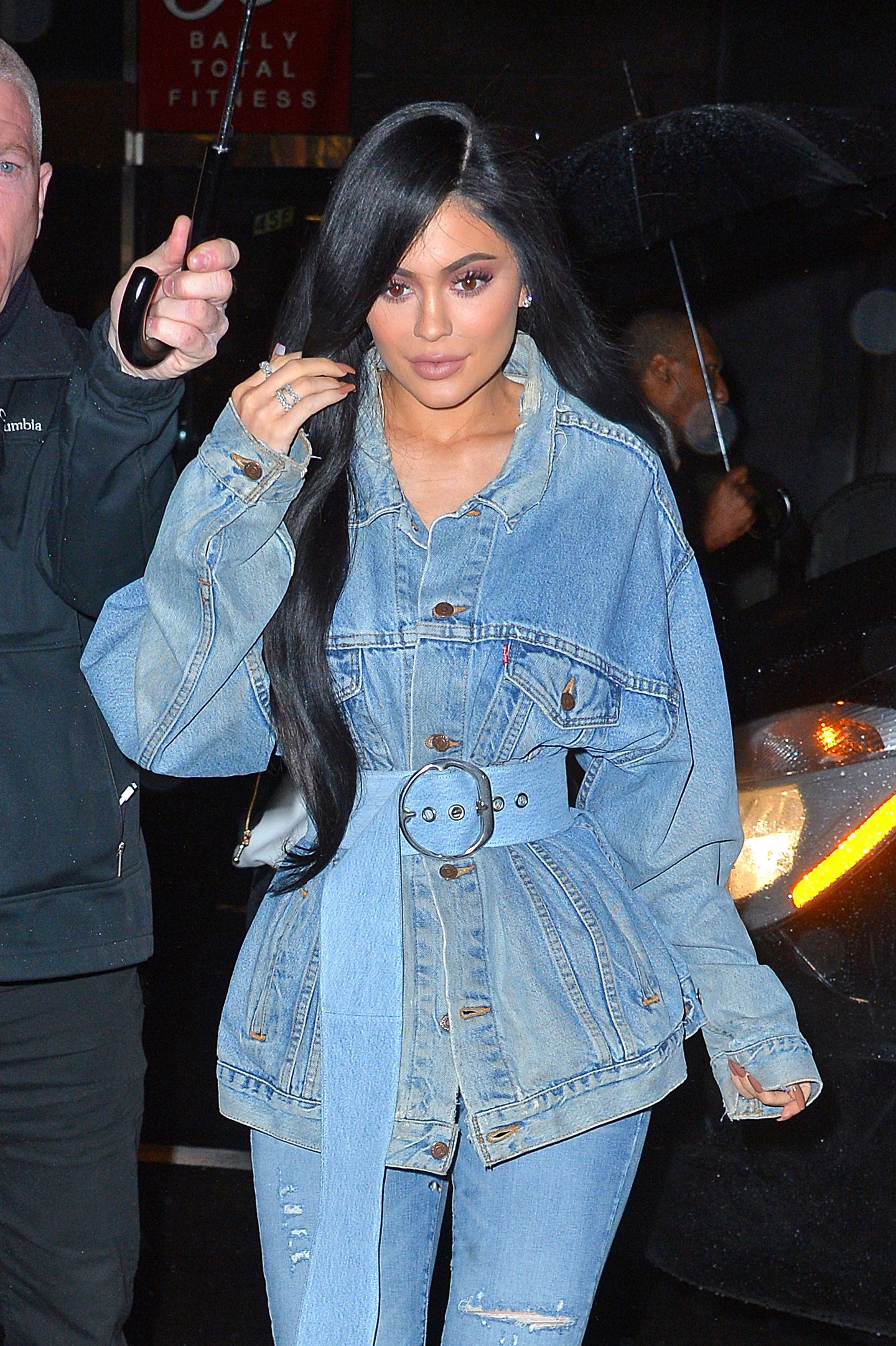 kylie jenner wearing a denim jacket and jeans with super long wavy black hair