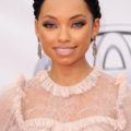 close up shot of logan browning with milkmaid braid, wearing pink dress and posing on the red carpet