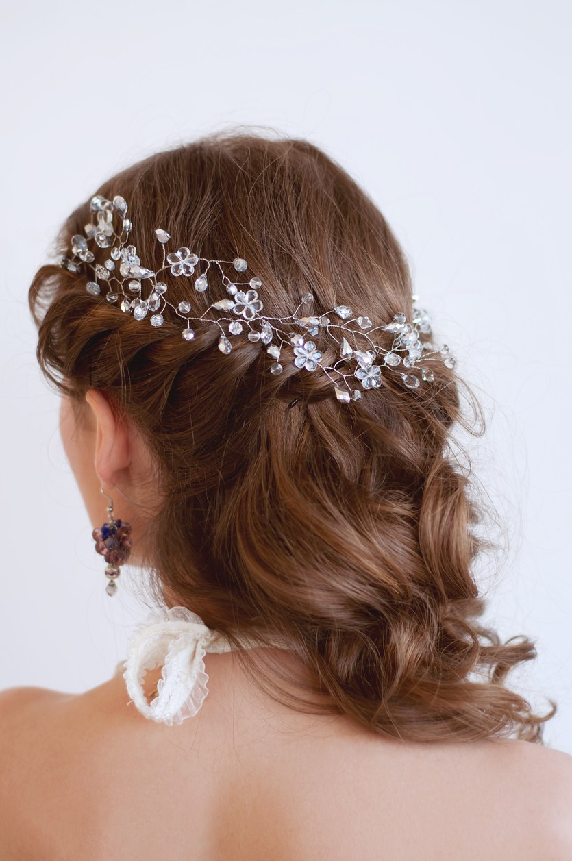 Brunette model with her hair in loose wavy curls with a braided detail