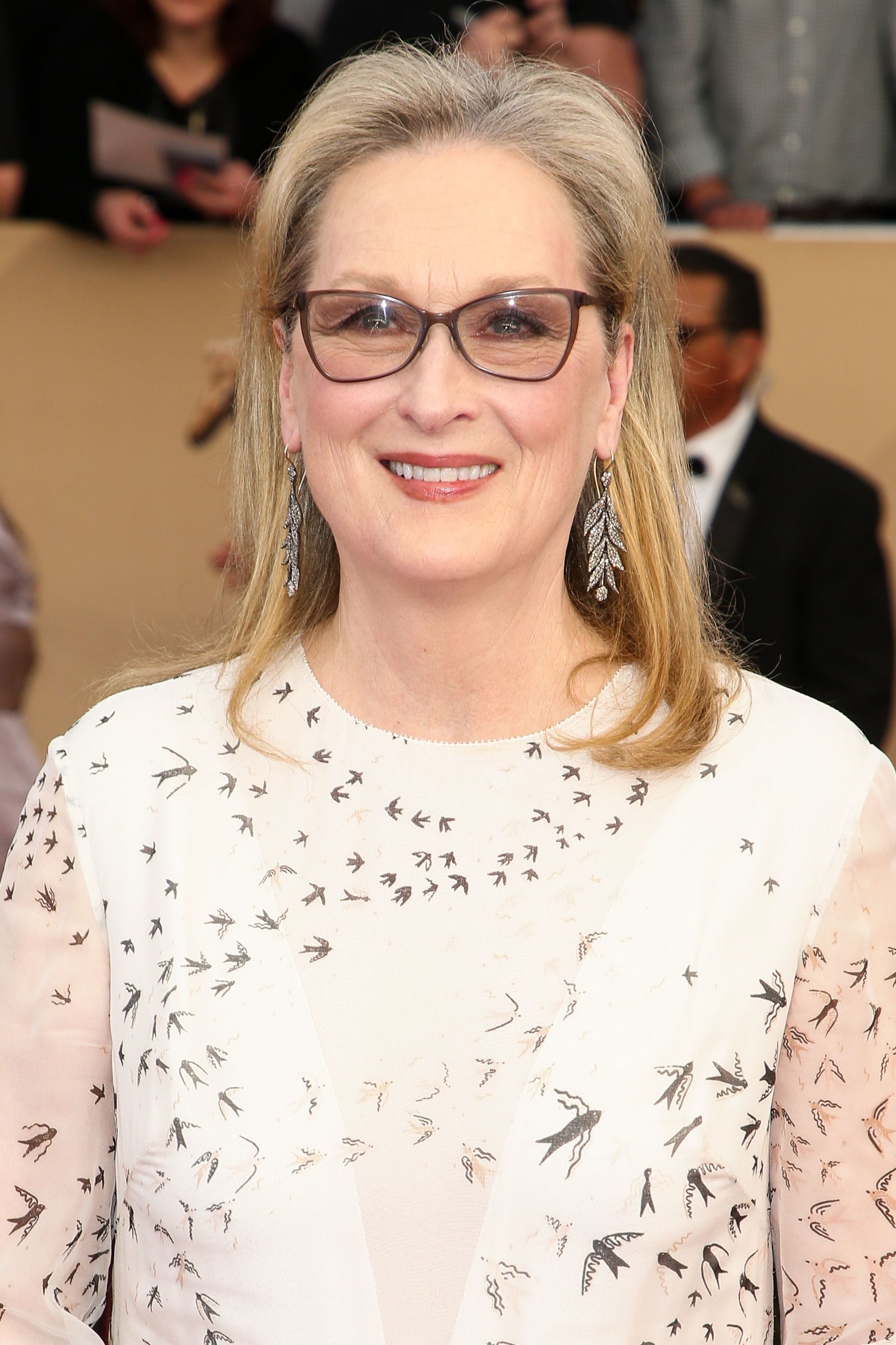 meryl streep wearing a white bird print dress with sleek straight blonde hair