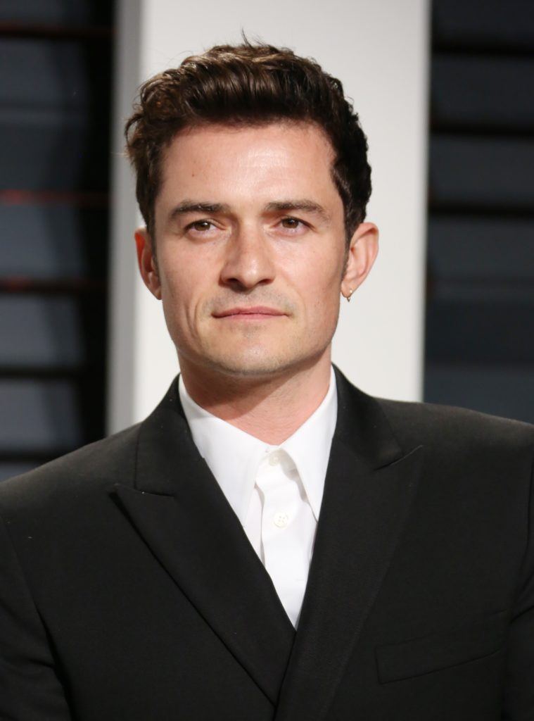 orlando bloom on the oscars 2017 red carpet wearing a black suit and white shirt with his dark brown hair worn in a quiff