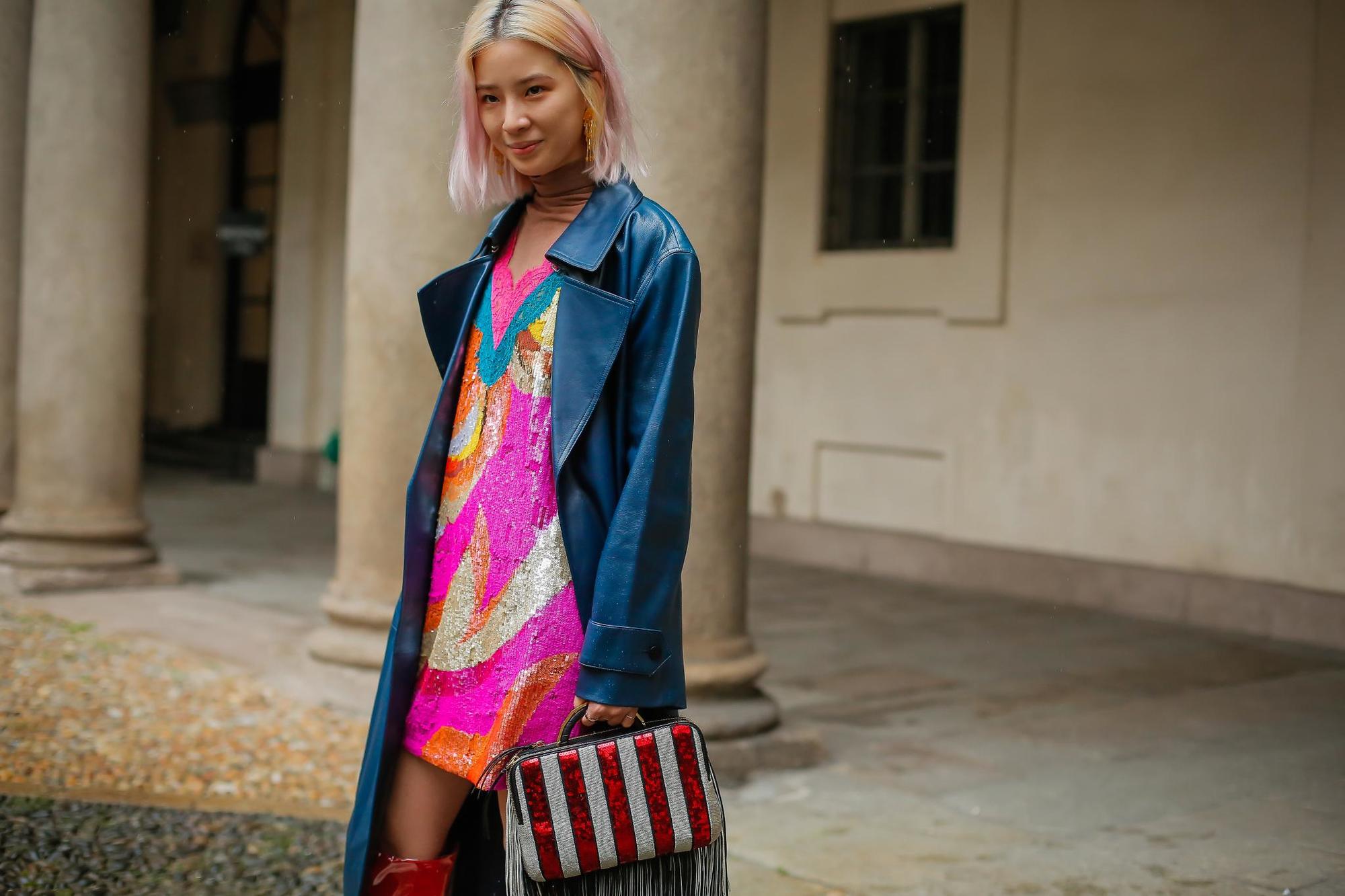 woman with yellow and pink ombre straight long bob in street style image wearing sequin dress and blue long leather coat