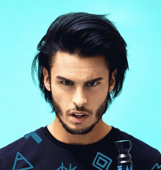 front view image of a man with longer dark hair in a quiff hairstyle