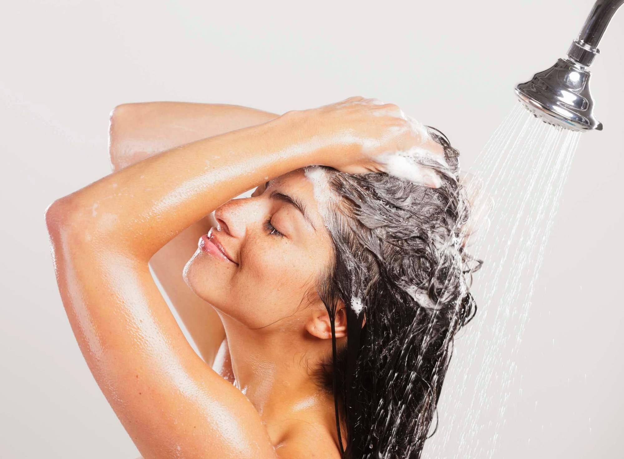 Brunette woman washing hair in shower