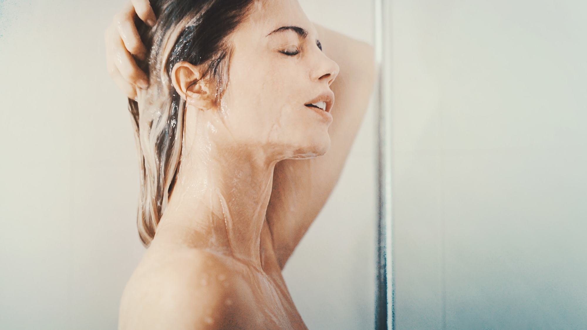 woman washing her dark hair in shower