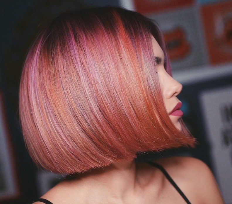 Short ombre hair: Woman with peachy multi coloured straight bob hair.
