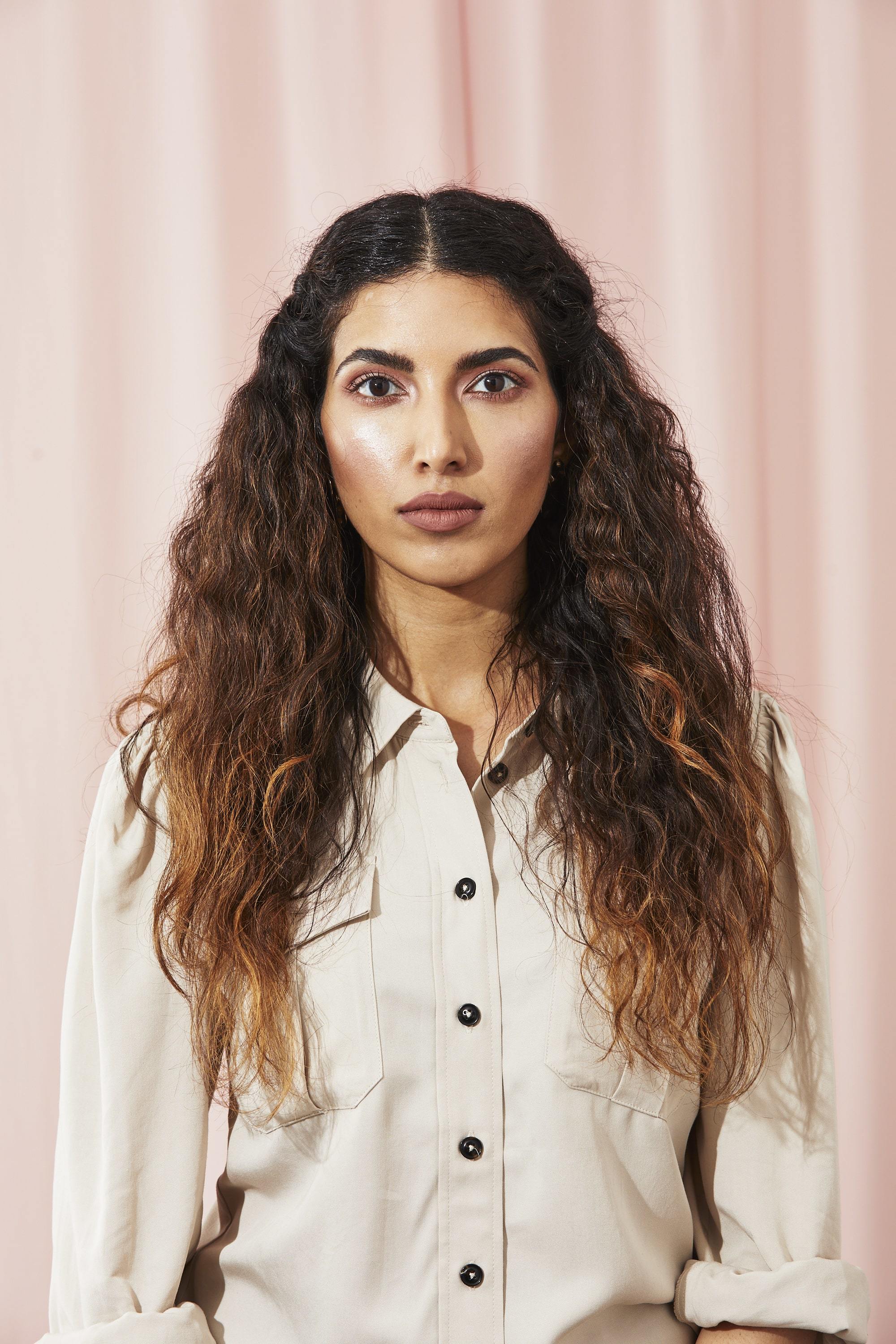 Woman with long curly brown hair with waterfall braid