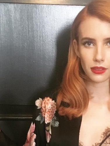 emma roberts with orange hair colour with red lipstick wearing a kimono