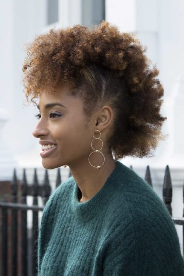 Easy hairstyles for short curly hair: Woman with afro mohawk AKA 'frohawk' on her golden brown natural hair.