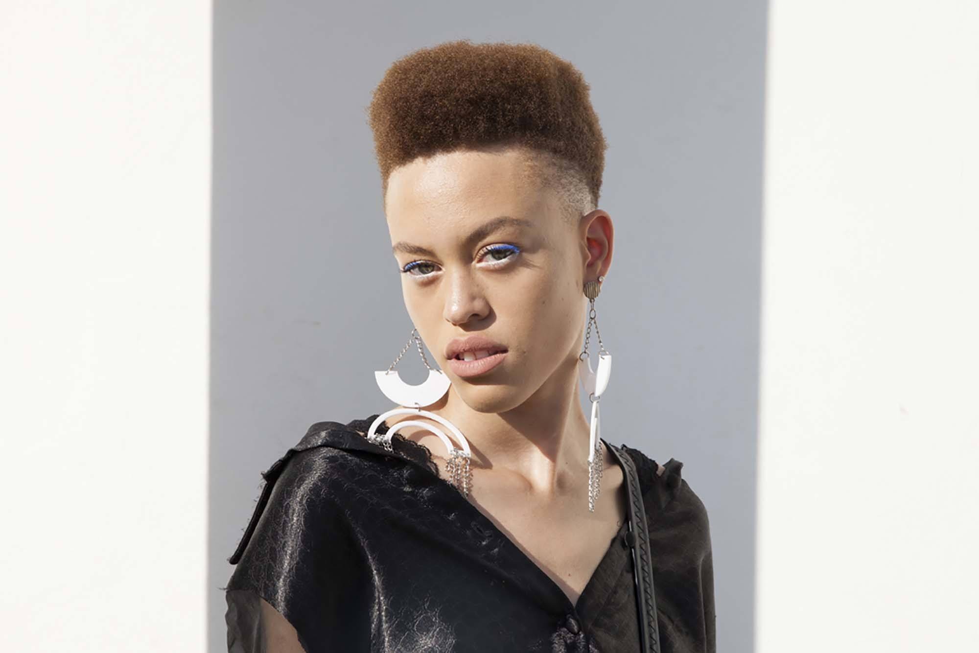 Easy hairstyles for short curly hair: Woman with natural afro hair in high top style.