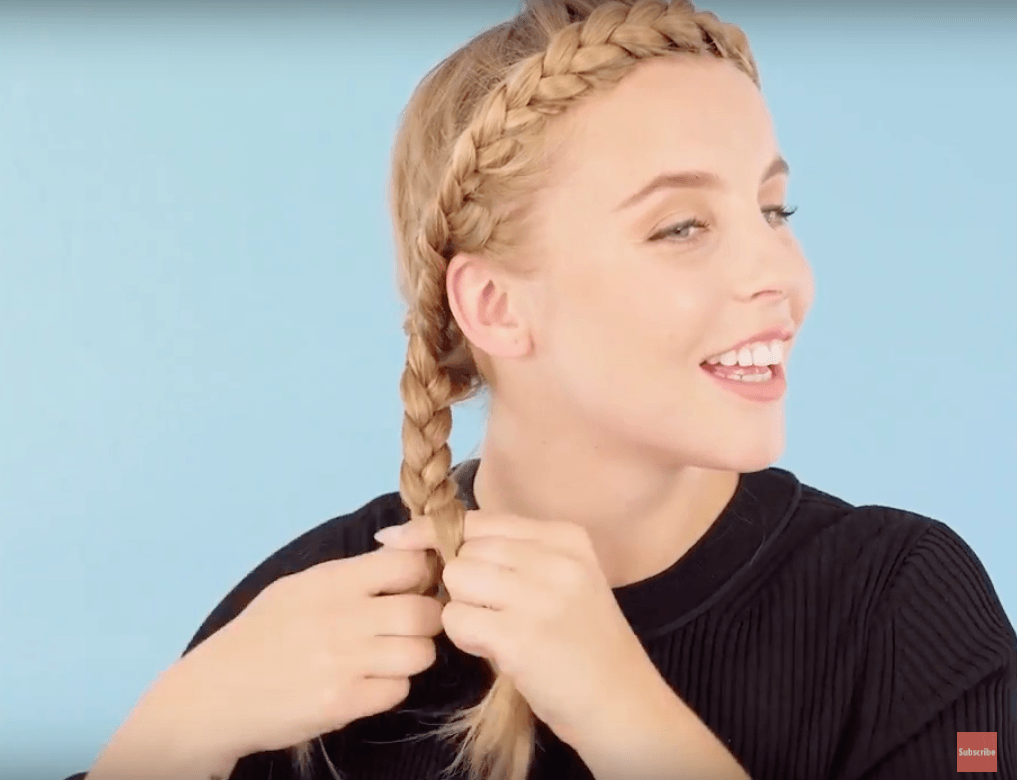 front view of blonde model braiding hair for halo braid tutorial