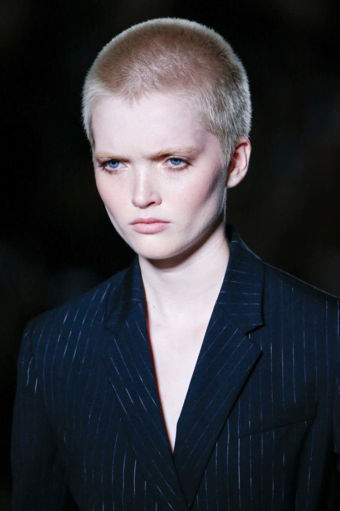fashion short hairstyles: model with a platinum blonde buzzcut on the runway