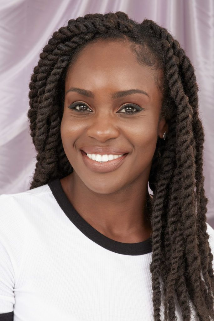 Marley braids final step: Woman with long, dark brown marley twists hair wearing white shirt, smiling and posing in the All Things Hair UK Studio