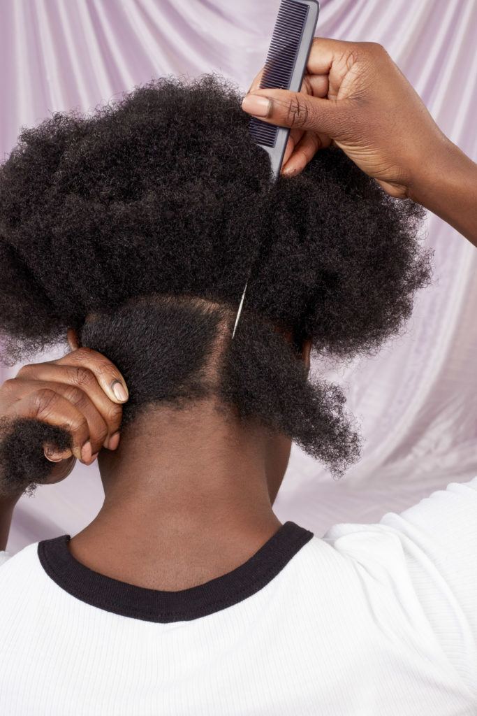 How to do your own marley braids: Shot of woman with natural hair sectioning into box parts in the All Things Hair UK Studio