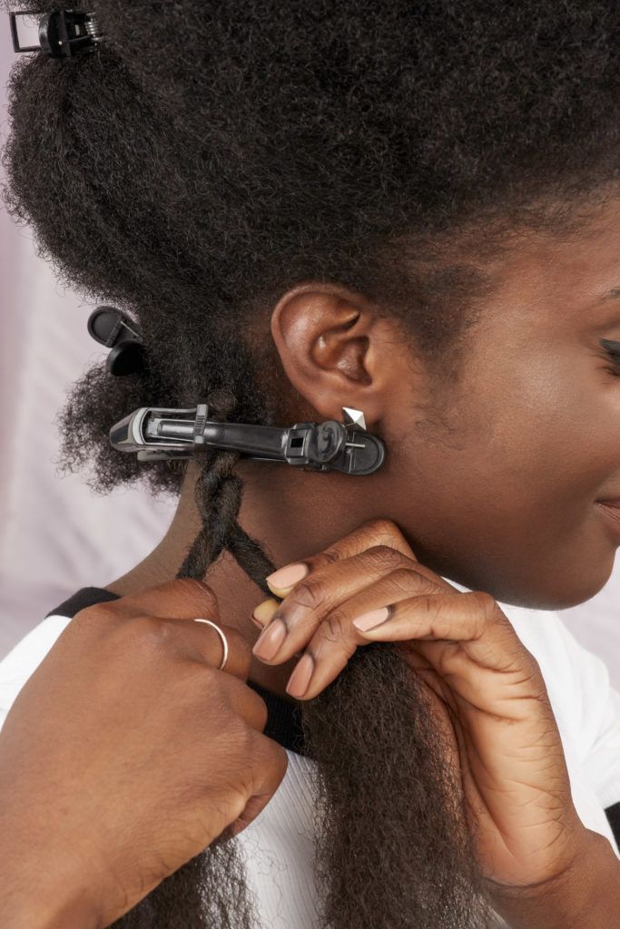 How to do marley braid hair: Woman twisting her marley hair around her hair in the All Things Hair UK Studio