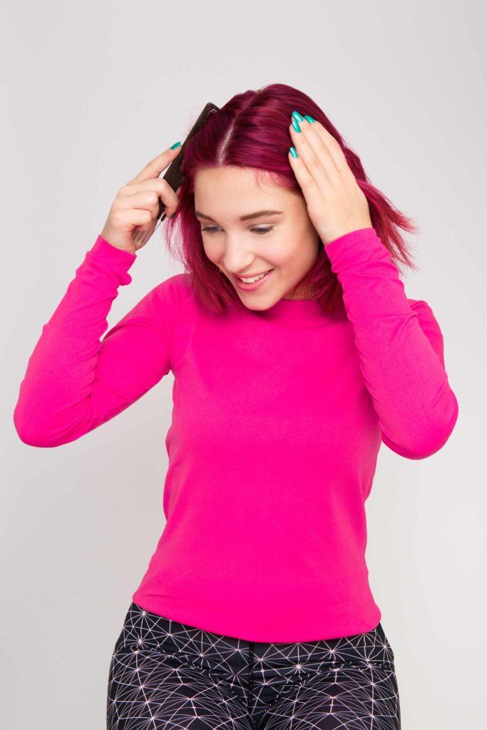 Double Dutch braids: red haired model divides hair down centre.