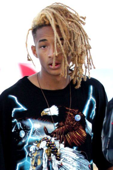 jaden smith with his blonde dreads in a tied up style wearing a printed tshirt