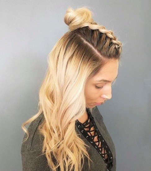 side view of a woman with long blonde hair and a hun braid hairstyle