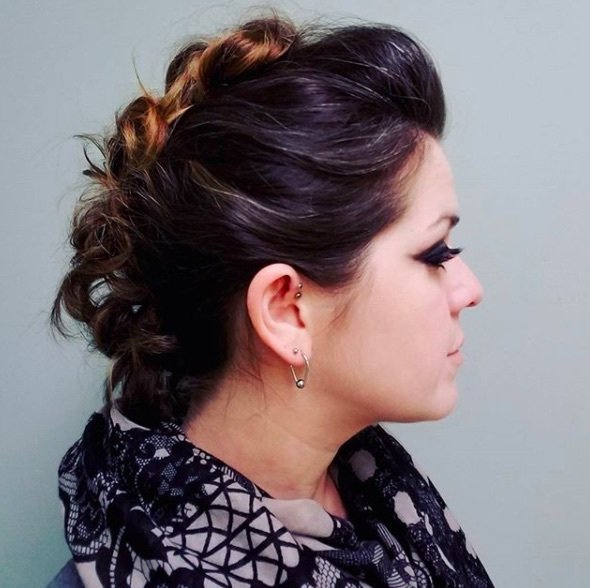 side view of a woman with brunette hair in a mohawk up do hairystyle