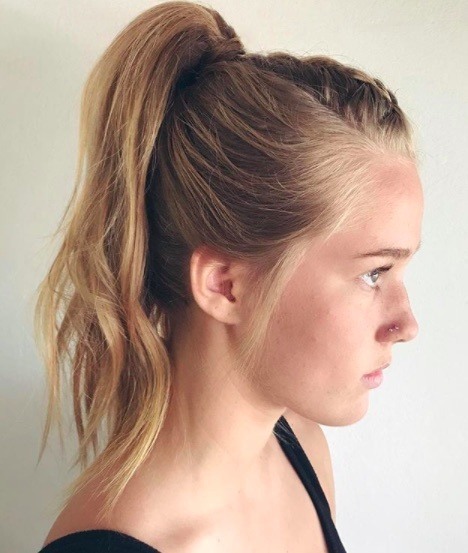 side view of a woman with her hair in a ponytail and braided mohawk style