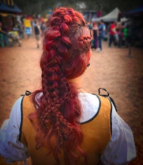 back view of a woman with red hair in a long braided mohawk style