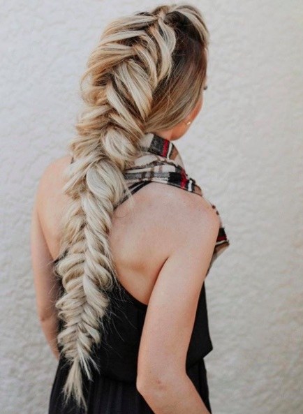 back view of a woman with a long blonde mohawk braid hairstyle