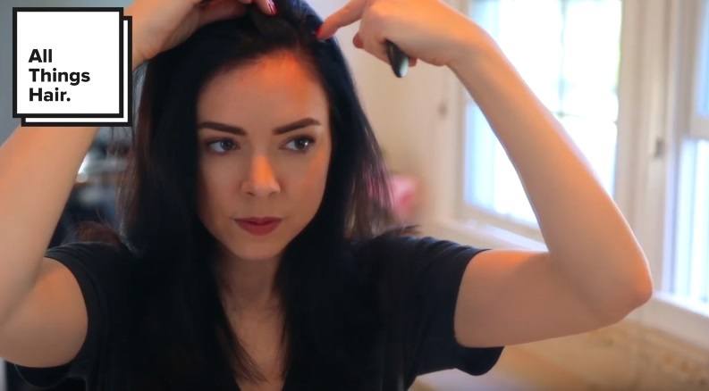 youtuber Nikki Phillippi sectioning her hair into a side parting