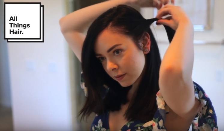 youtuber Nikki Phillippi twisting a section of her hair