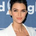 coloured braids: close up shot of ruby rose with long pixie hair with ombre emerald ends styled into a crown braid, wearing white and posing on the red carpet