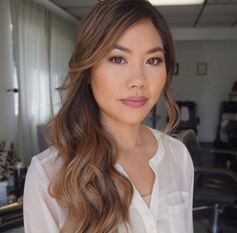 woman with long thick wavy hair swept to the side