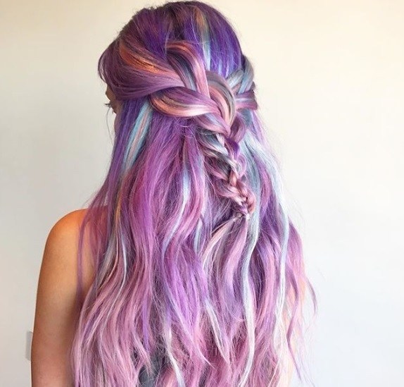 coloured braids: close up shot of a woman with coloured half-up, half-down braid hairstyle, standing against a white background