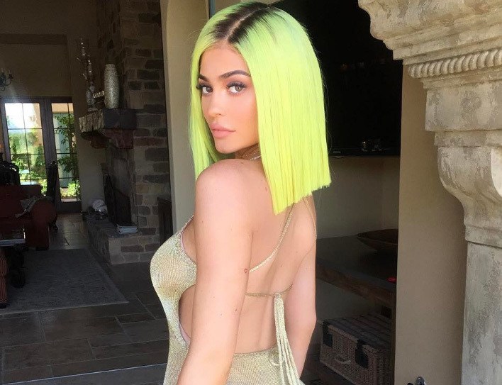 kylie jenner with yellow neon hair at coachella wearing gold
