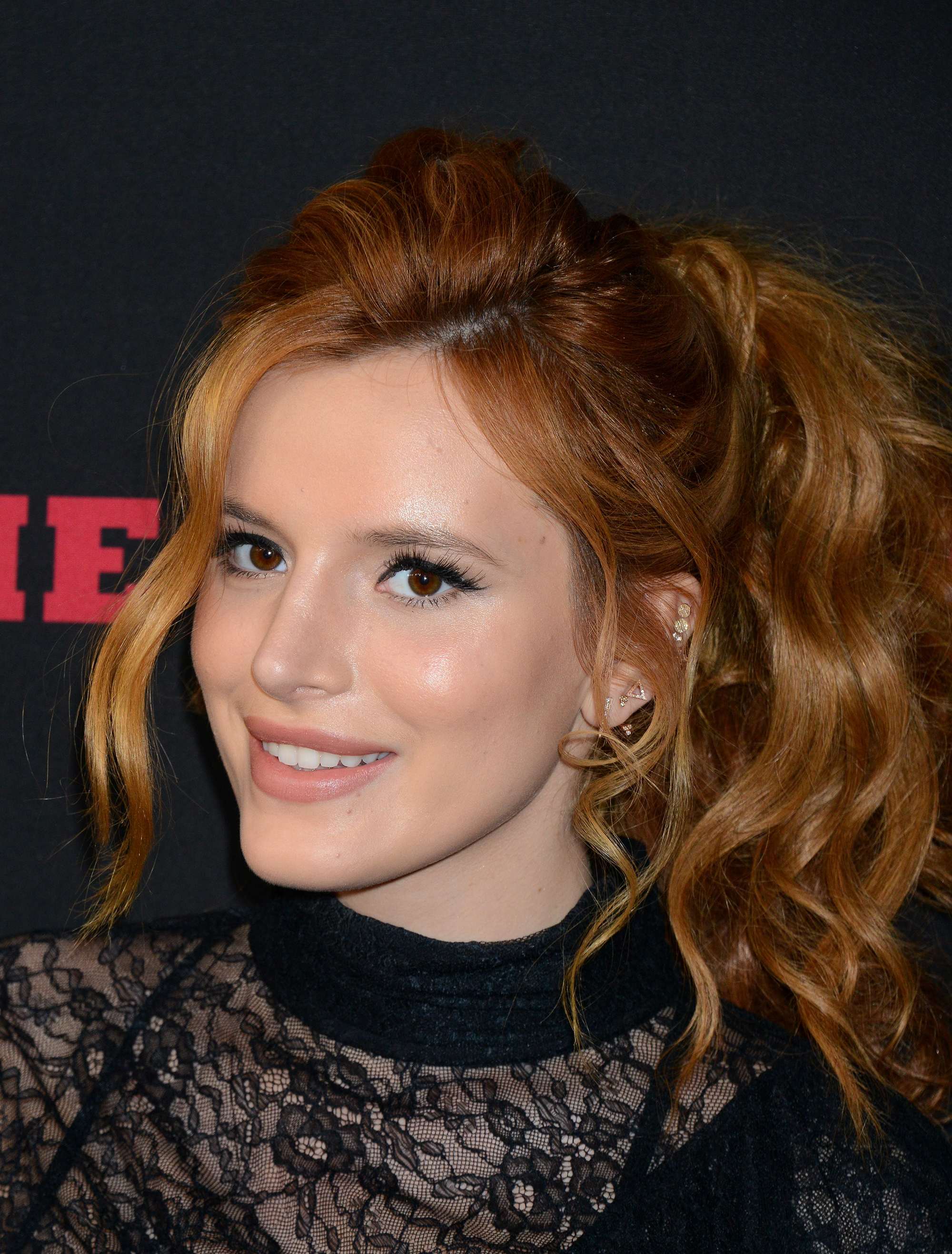 actress bella thorne with red hair in a glam curly ponytail