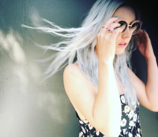 actress billie lourd wearing a daisy print dress and sunglasses with long silver grey hair