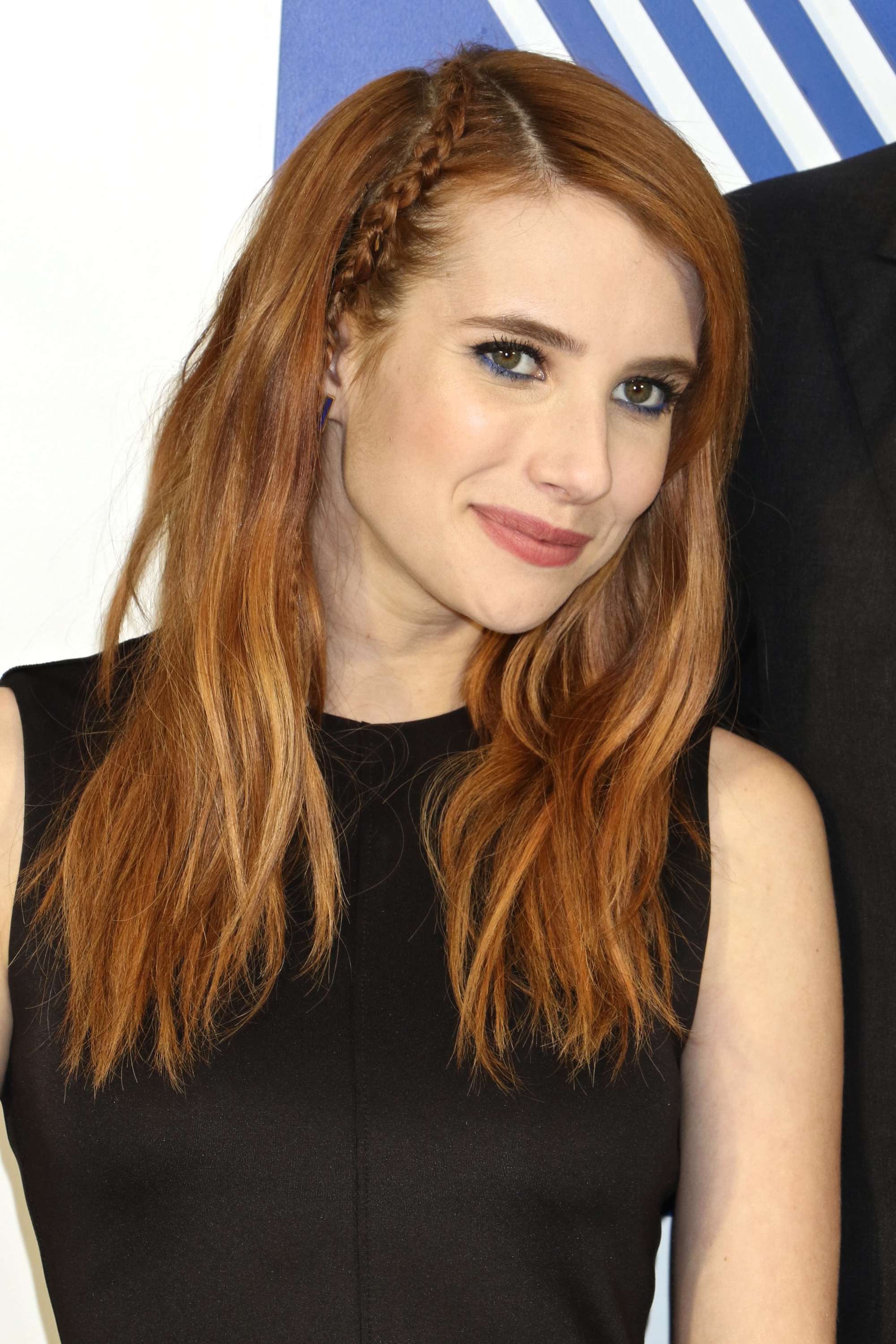 emma roberts with her light auburn hair down with a parting braid