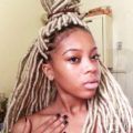 woman with faux blonde locs in half-up bun