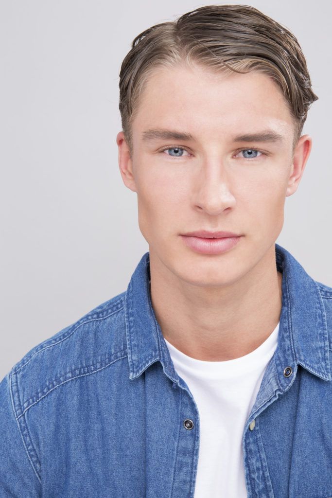 blonde male model wearing a white tshirt and blue shirt with wet hair