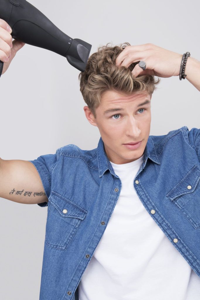 blonde male model drying his hair with a hairdryer