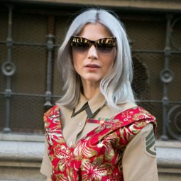 street style blogger at milan fashion week wearing a red floral dress with grey medium length hair