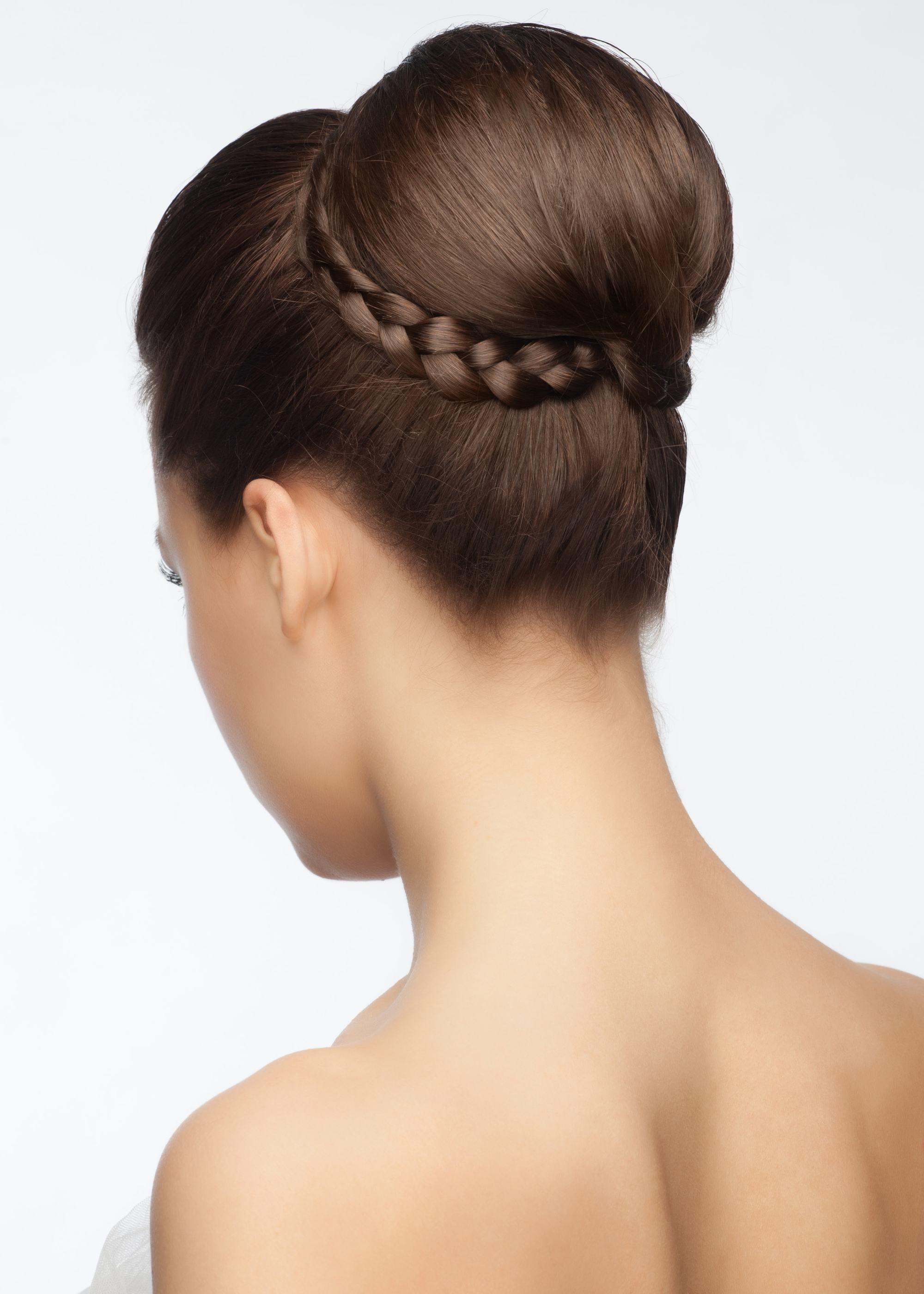 Brown hair in high chignon hairstyle wrapped with a braid