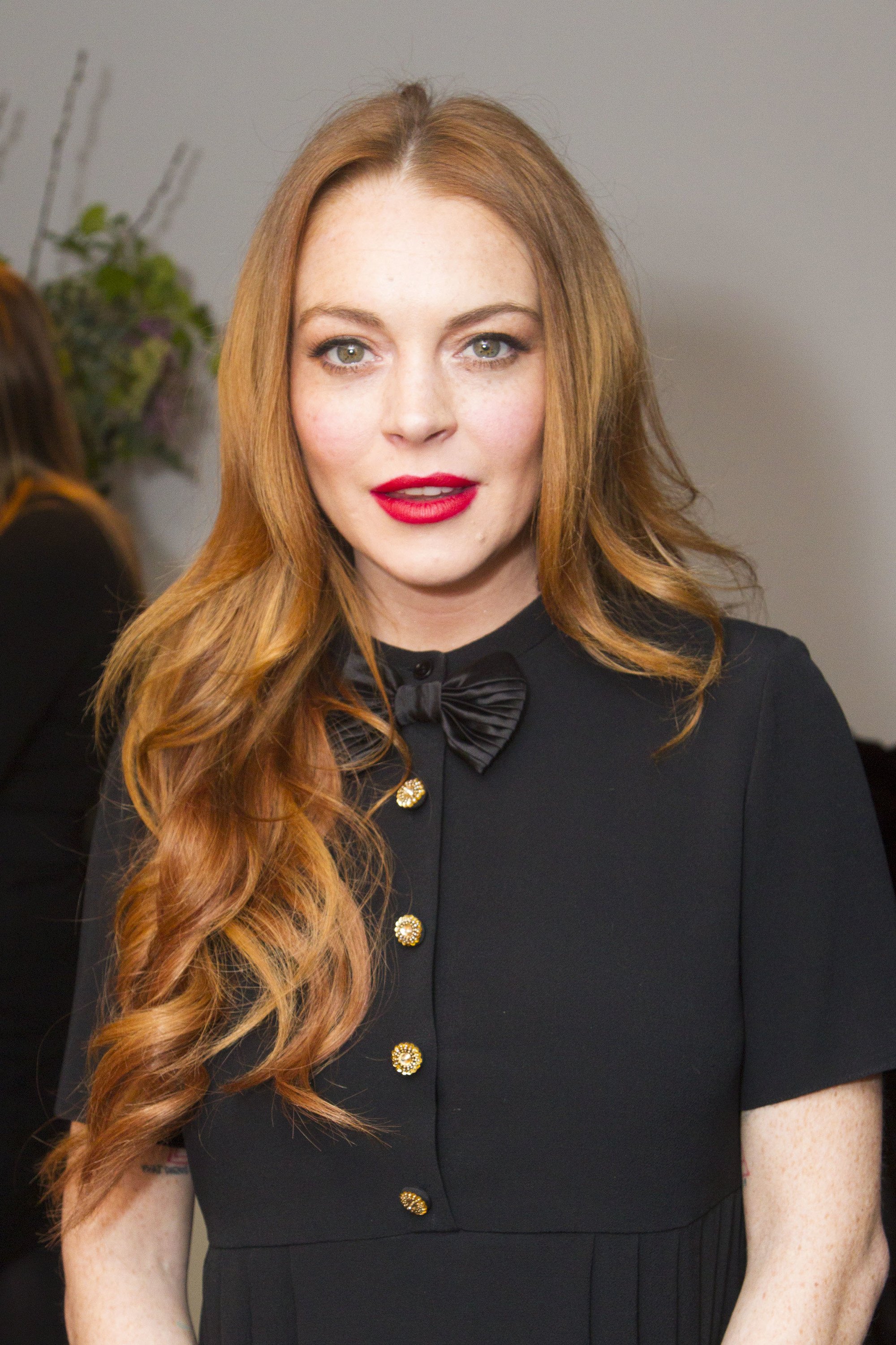 lindsay lohan with her red hair in a sideswept curly style