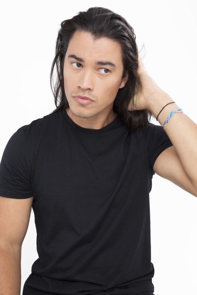 Dark haired man applying product to his dark brown hair