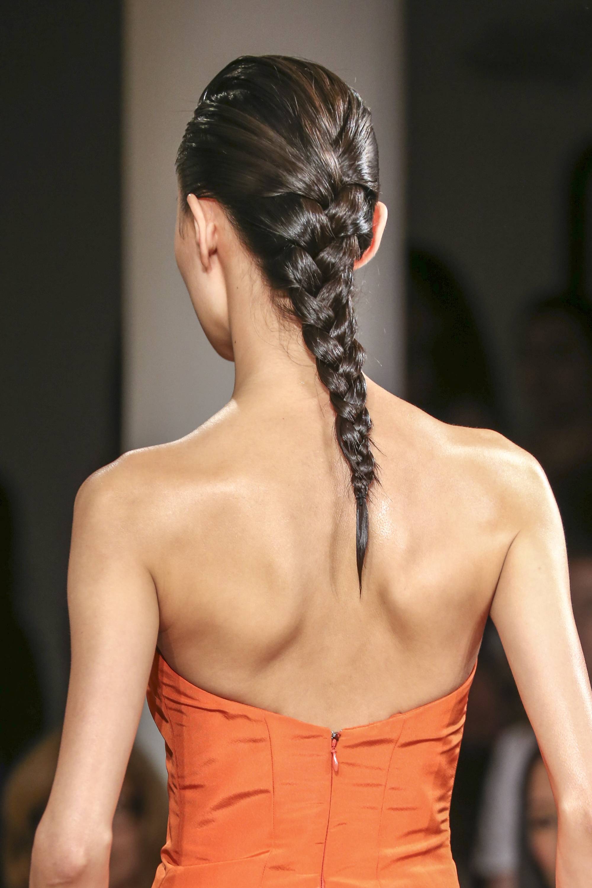 peter som model wearing an orange dress with her brunette hair in a french plait
