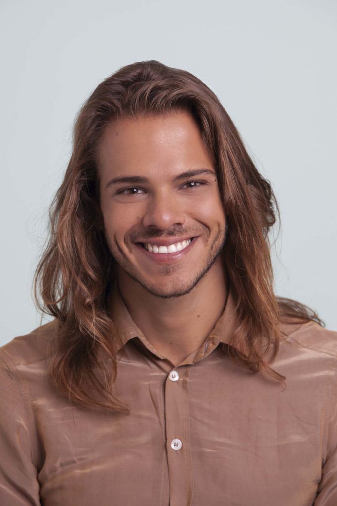 a long hair mman smiling to the camera